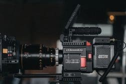 Professional cinema camera setup with a red camera body and an orion anamorphic lens.