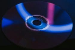 A close up of a DVD on a dark surface.