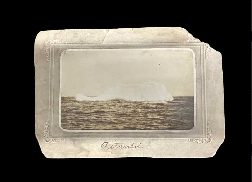 Old photograph of an iceberg at sea in a vintage, ornate frame, labeled "titanic" at the bottom.