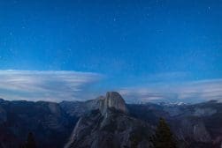 A night sky filled with stars above half dome in yosemite national park.