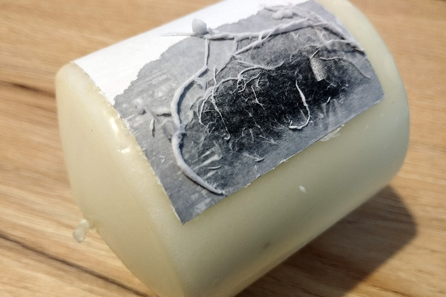 A bar of soap with a black-and-white photo label depicting historical agricultural work, placed on a wooden surface.