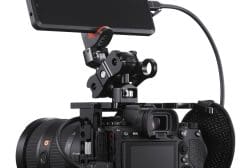 A professional digital camera equipped with a long lens and a mounted external monitor, all attached to a stabilizing rig.