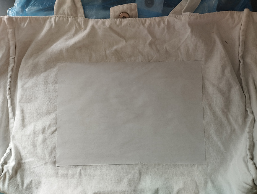 Canvas tote bag with a blank white label.