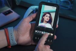 A person edits a photo of a woman on a smartphone screen using an image editing app.