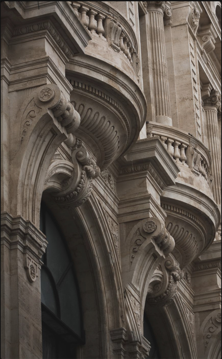 Ornate stone facade with detailed arches, columns, and decorative carvings in classical architectural style.
