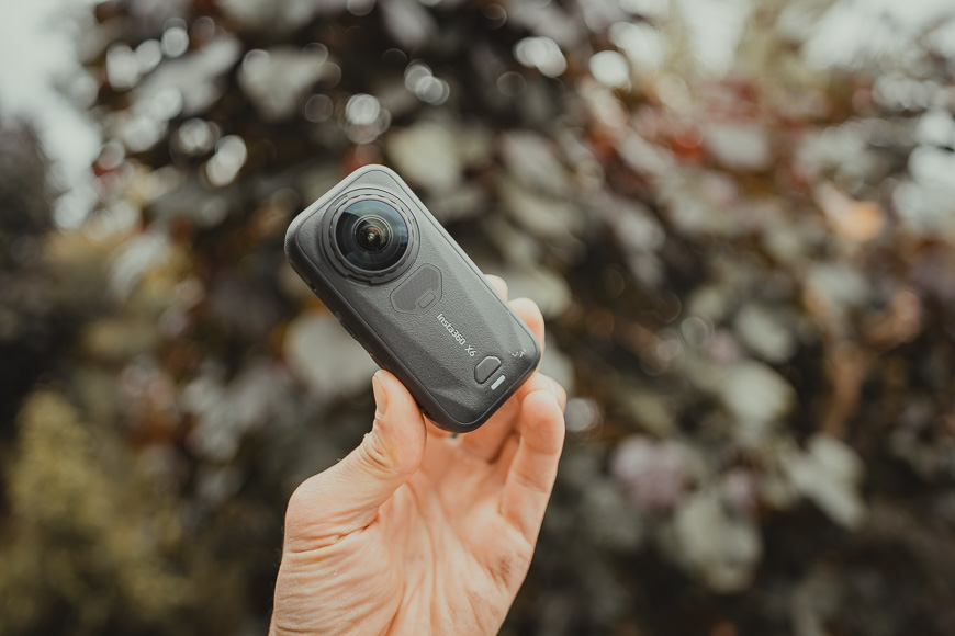 Hand holding an Insta360 X4 action camera.