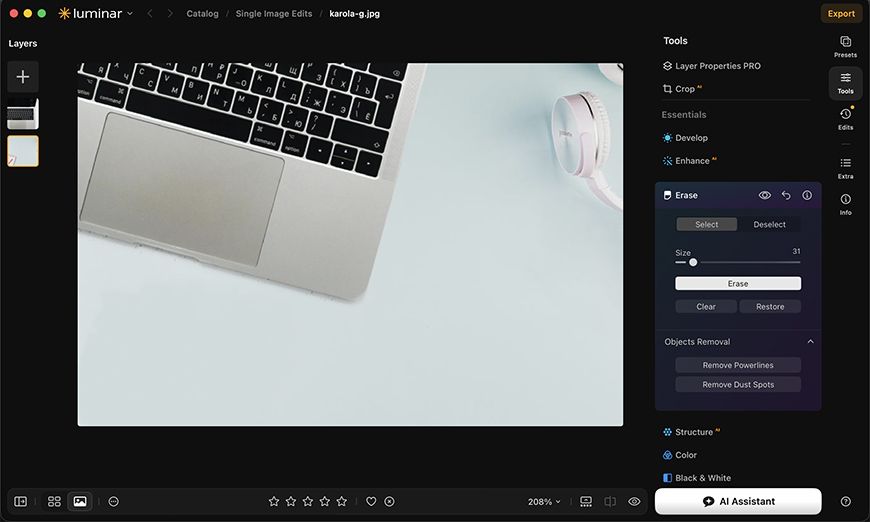 The Luminar photo editing software interface showing an image of a laptop and headphones with the Erase tool panel open.