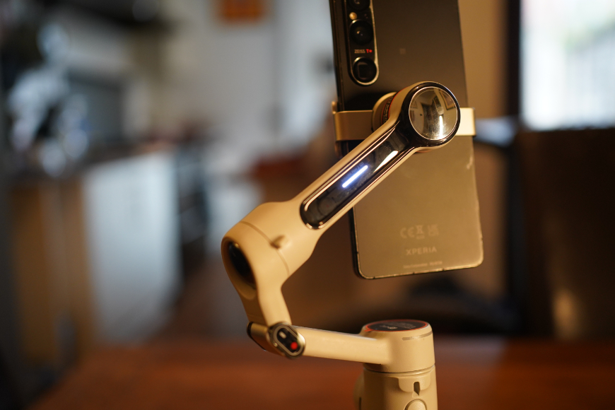 A smartphone mounted on a motorized gimbal stabilizer.