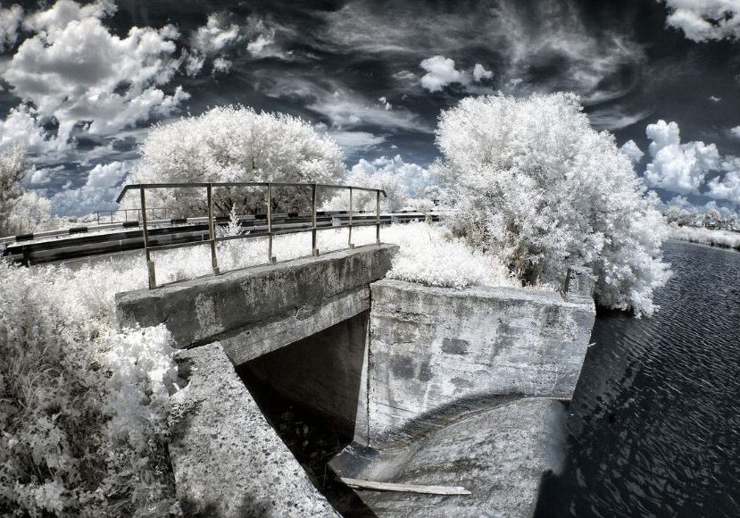 An infrared photo of a bridge over a river.