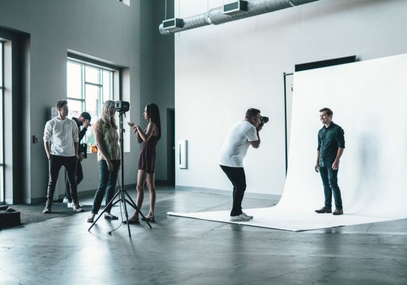 A group of people taking pictures in a studio.