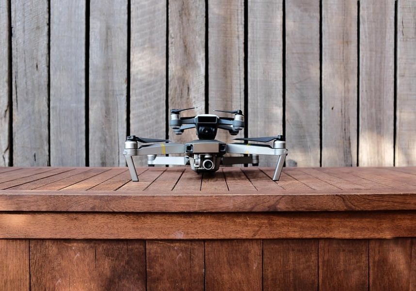 a small remote controlled flying drone on top of a wooden table.