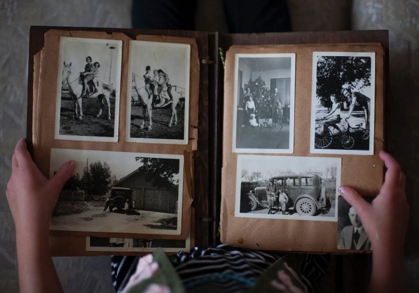A person holding an old photo album.