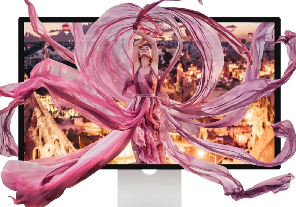 A dancer in a flowing pink costume appears to leap out of a computer monitor against a blurred cityscape background.