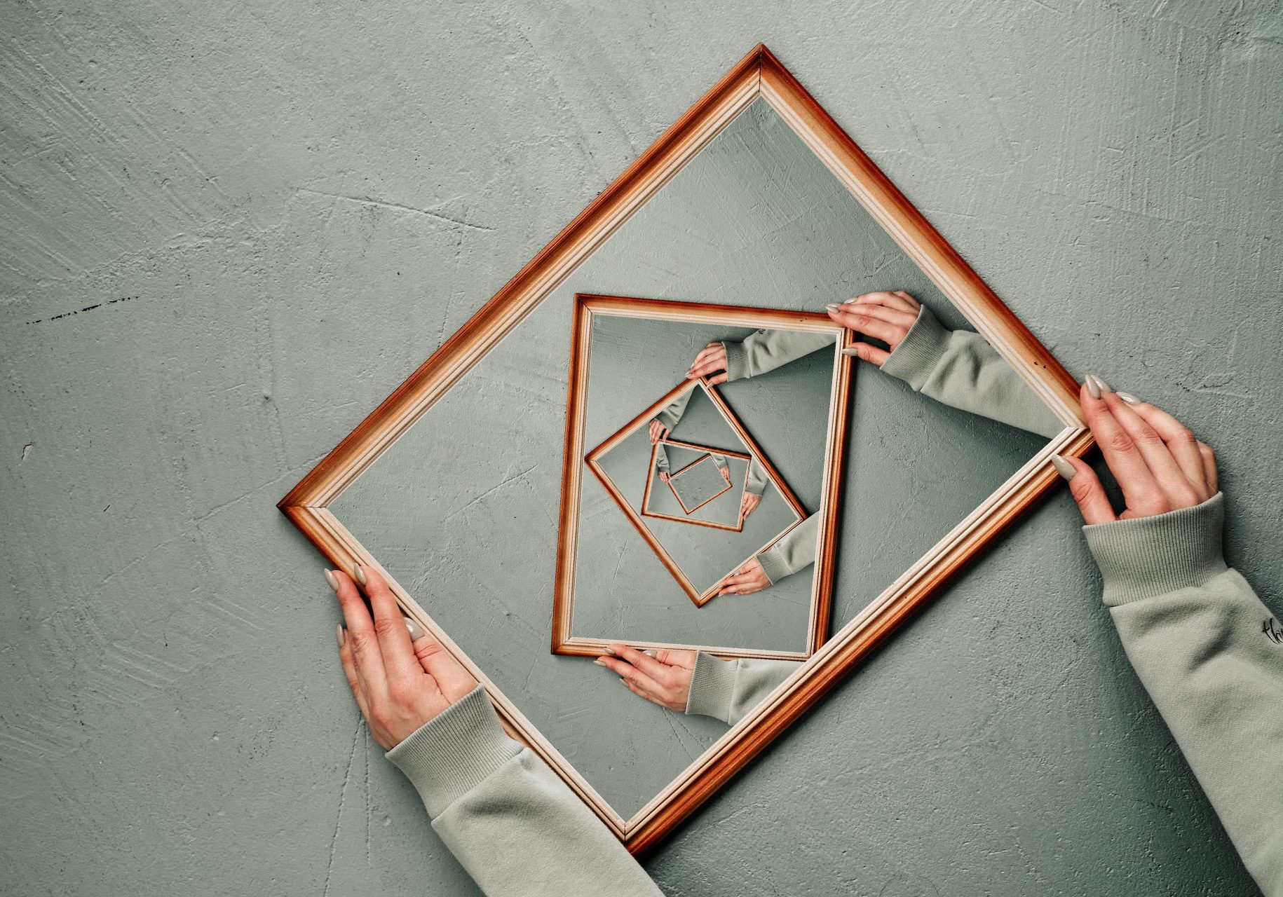 A person holding a mirror with a square in it.