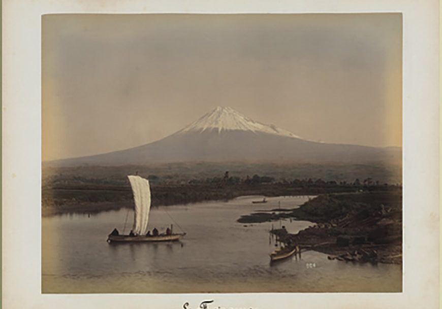a boat in the water with mount Fuji in the background.