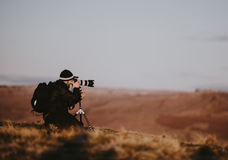 photographer holding camera in field