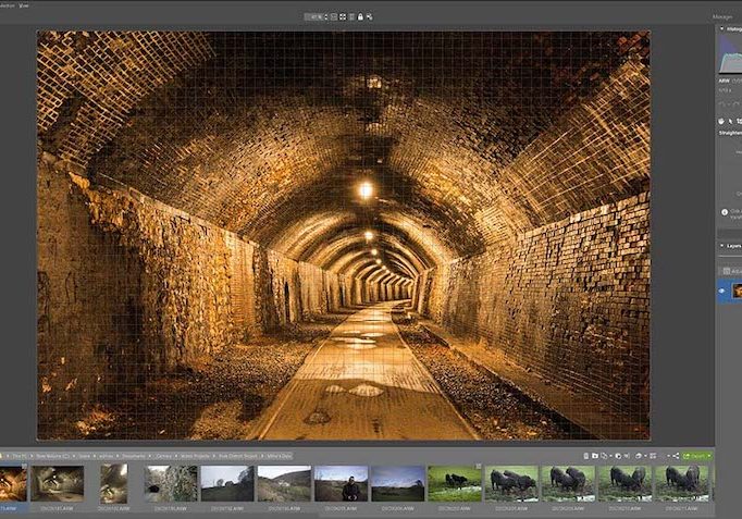 A screenshot of a photo editing software interface displaying an image of a brick-lined tunnel with arched ceiling and lights.