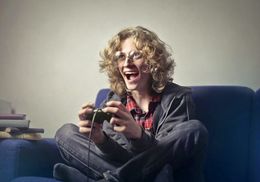 A young man sitting on a couch holding a video game controller.