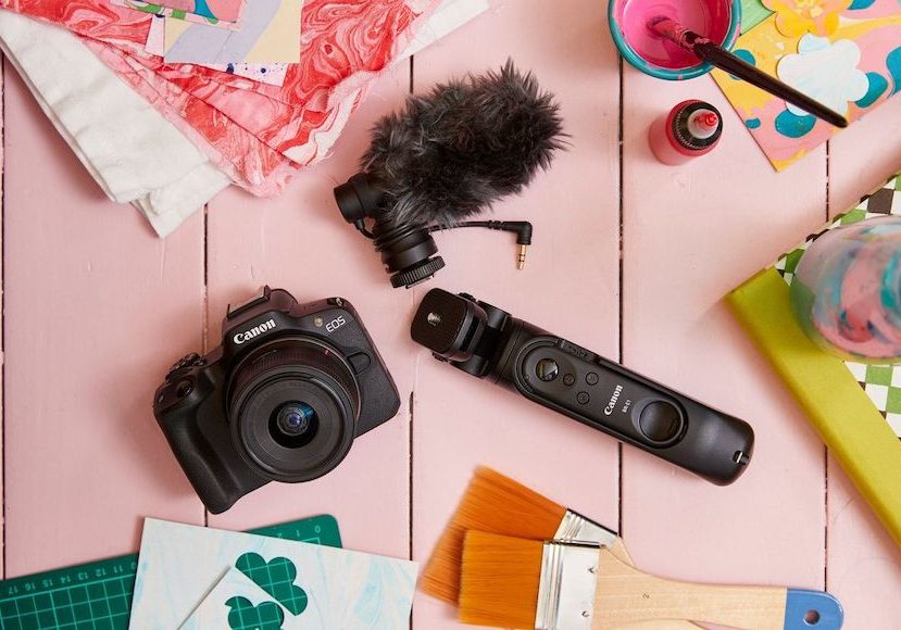 A camera and other objects on a pink table.