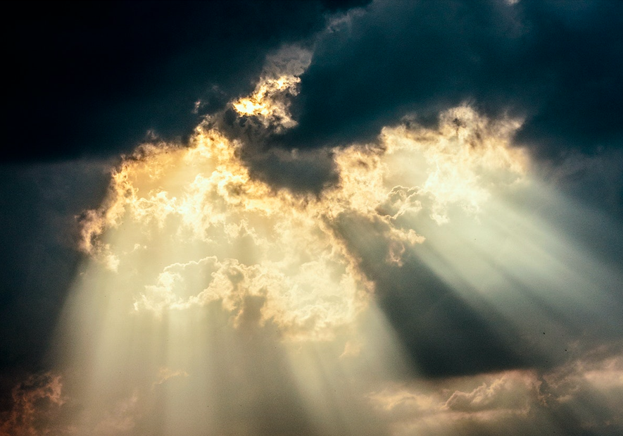 Rays of light shining through a cloudy sky.