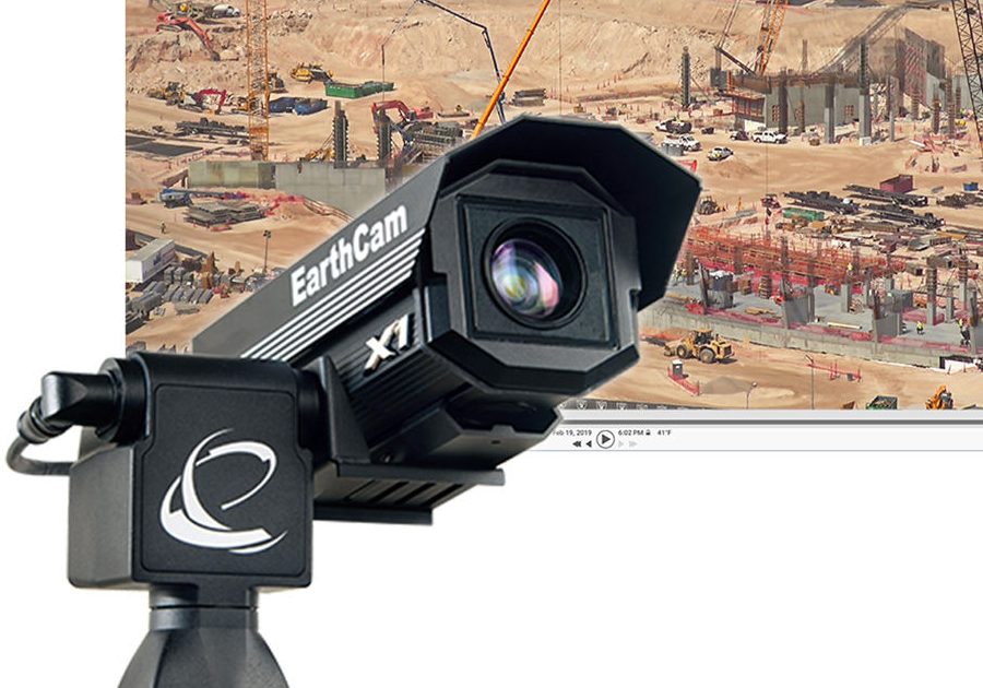 a camera is on a tripod in front of a construction site.