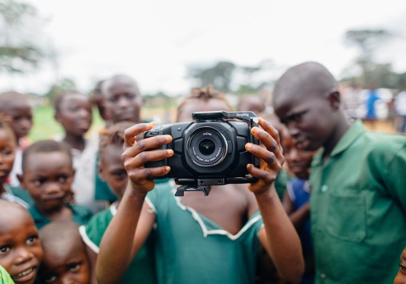 A group of children taking a picture with a camera.