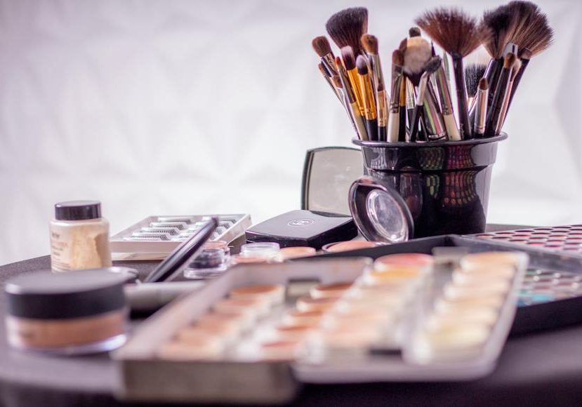 Makeup brushes and cosmetics on a table.
