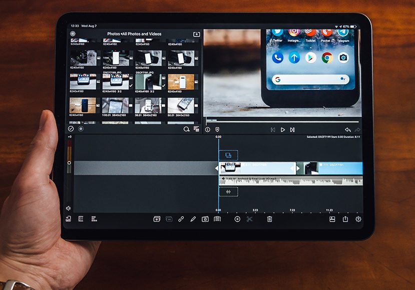 a hand holding a tablet with a video editing app on it.