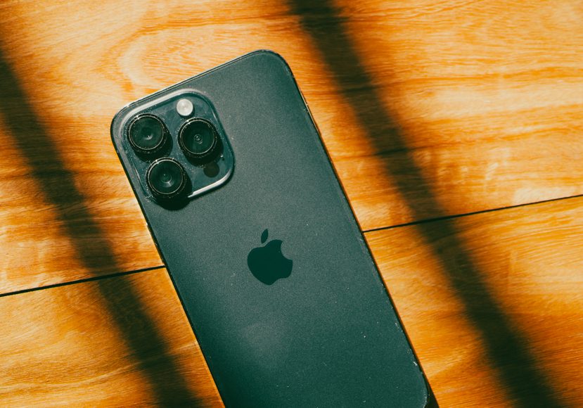 a close up of a iphone 14 on a wooden surface.