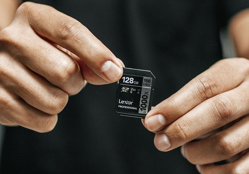 a person holding a small micro sd card.