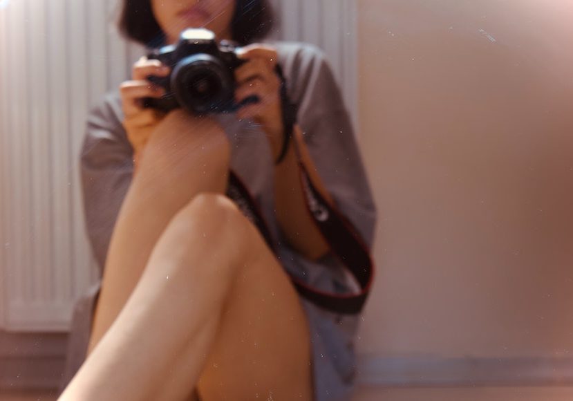 A woman taking a picture with a camera.