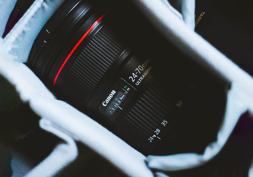 a close up of a canon usm camera lens in a bag.